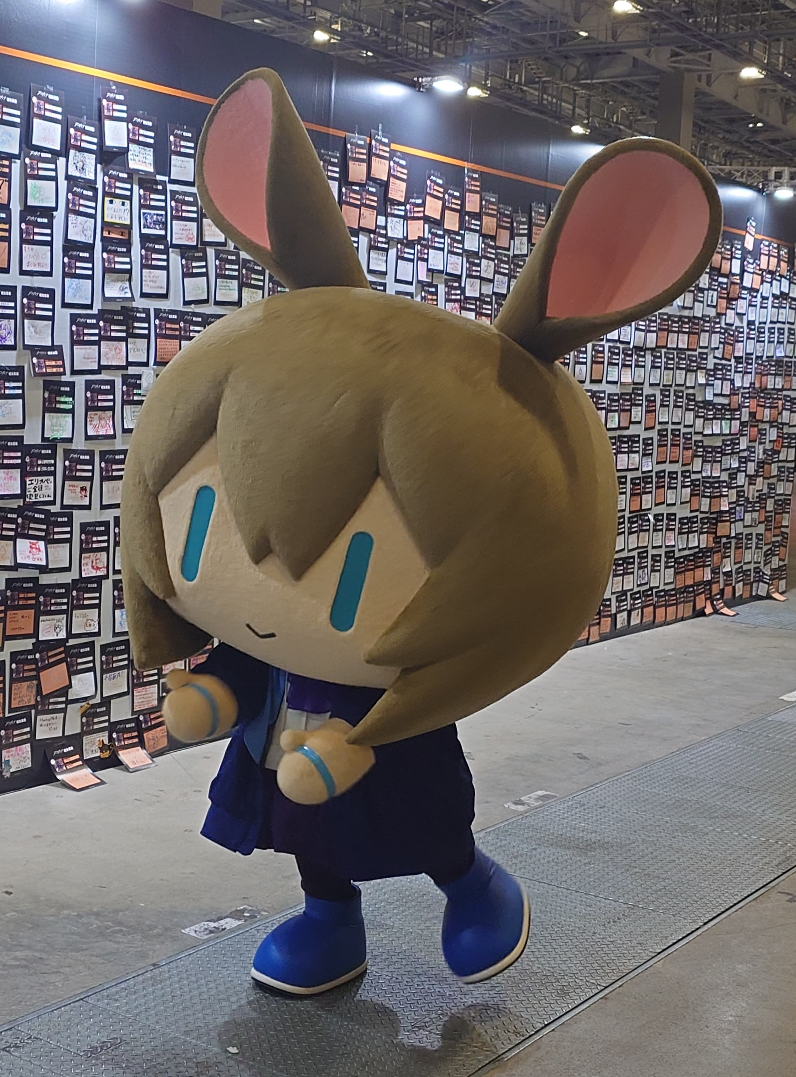 手を伸ばしてかわいいポーズを取るアーミヤの着ぐるみ